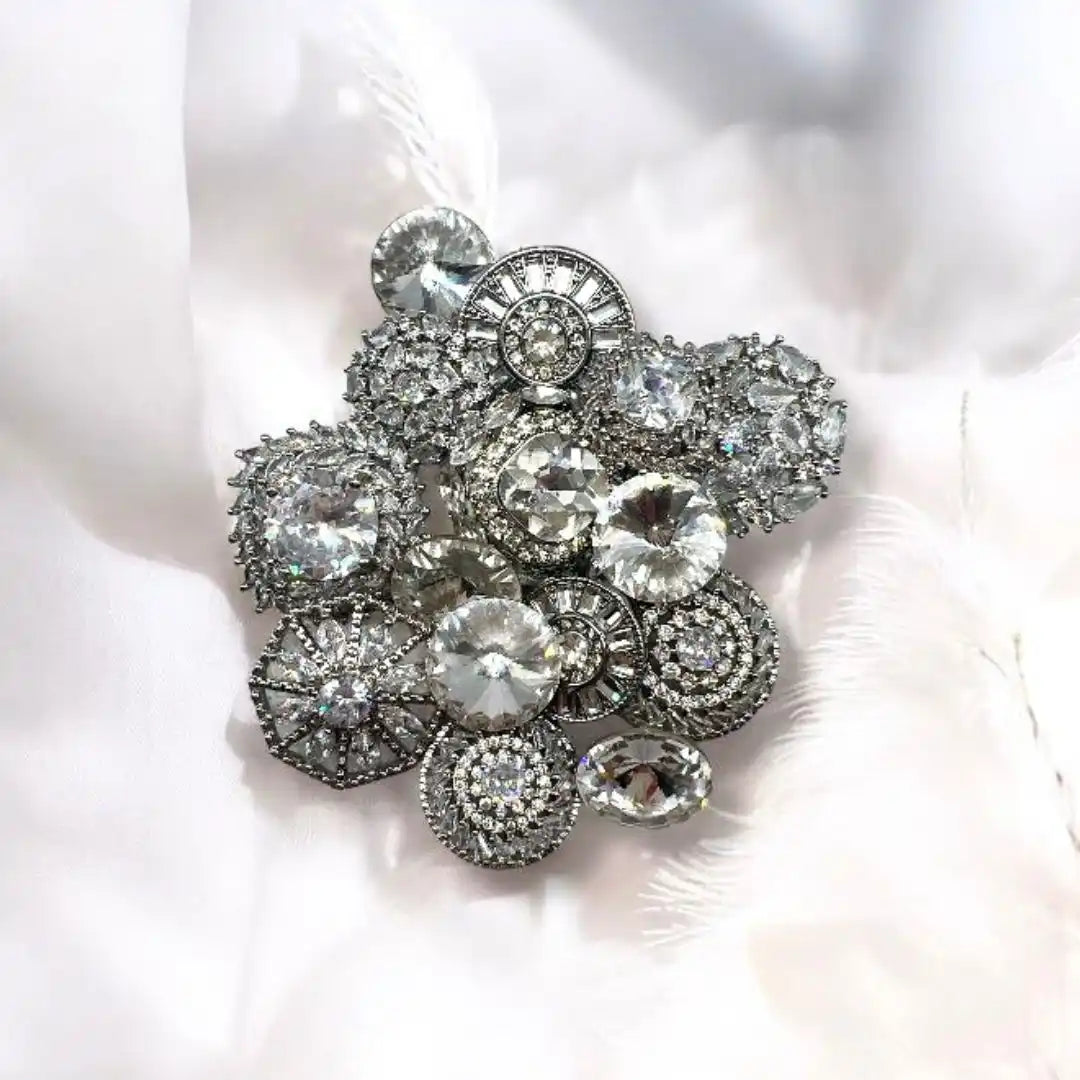 A cluster of silver-toned, crystal-embellished buttons and brooches.