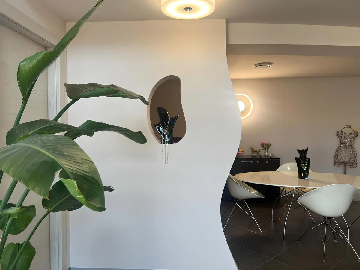 Indoor plant with large green leaves and a decorative wall niche.